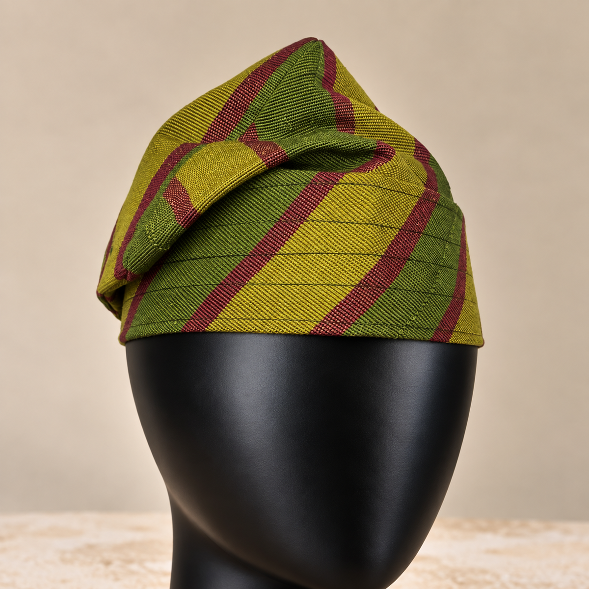 Green handmade Yoruba Fìlà cap, angled view