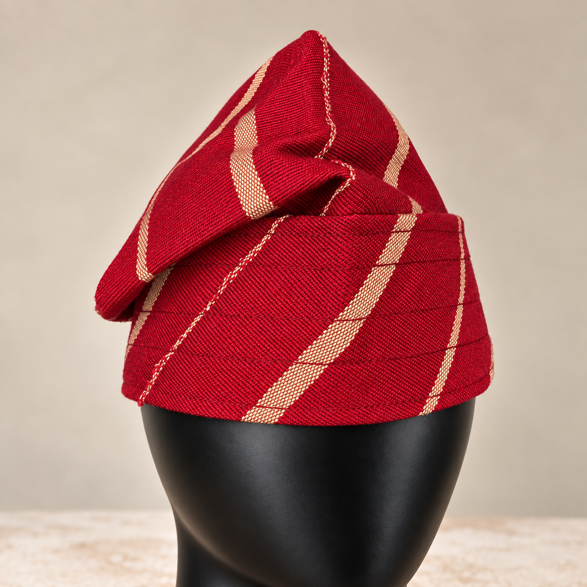 Red handmade Yoruba Fìlà cap, angled view