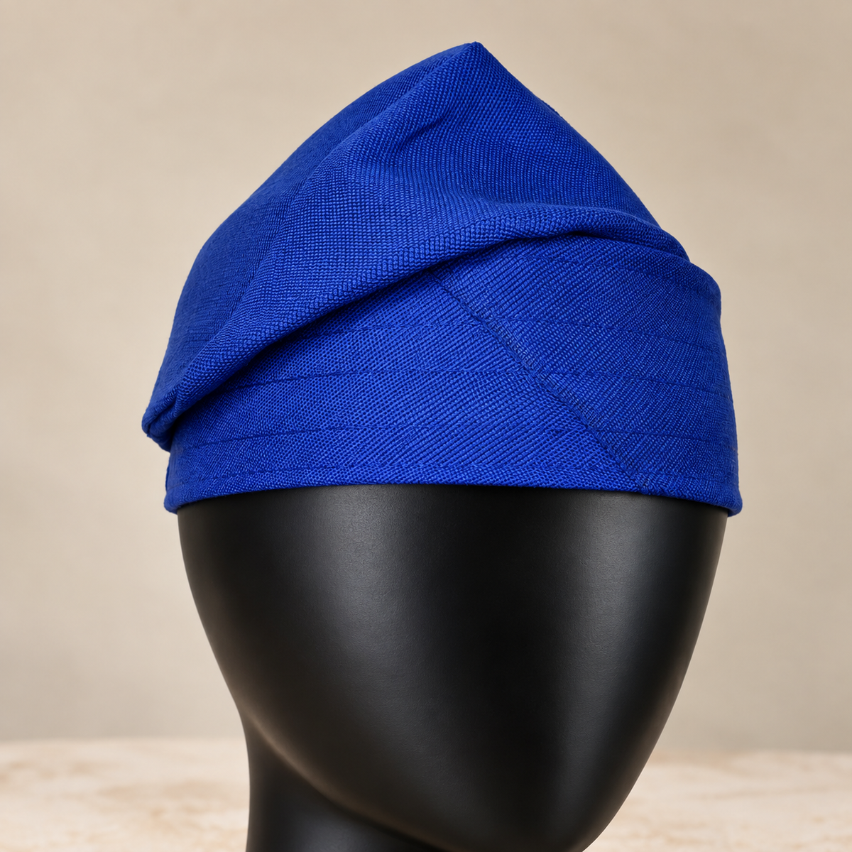 Blue handmade Yoruba Fìlà cap, angled view