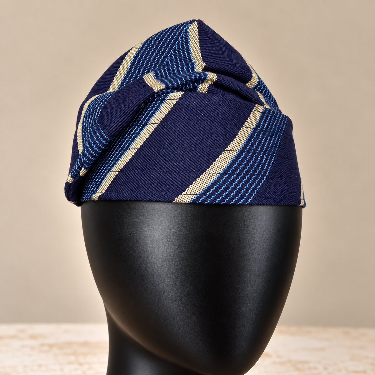 Blue handmade Yoruba Fìlà cap, angled view