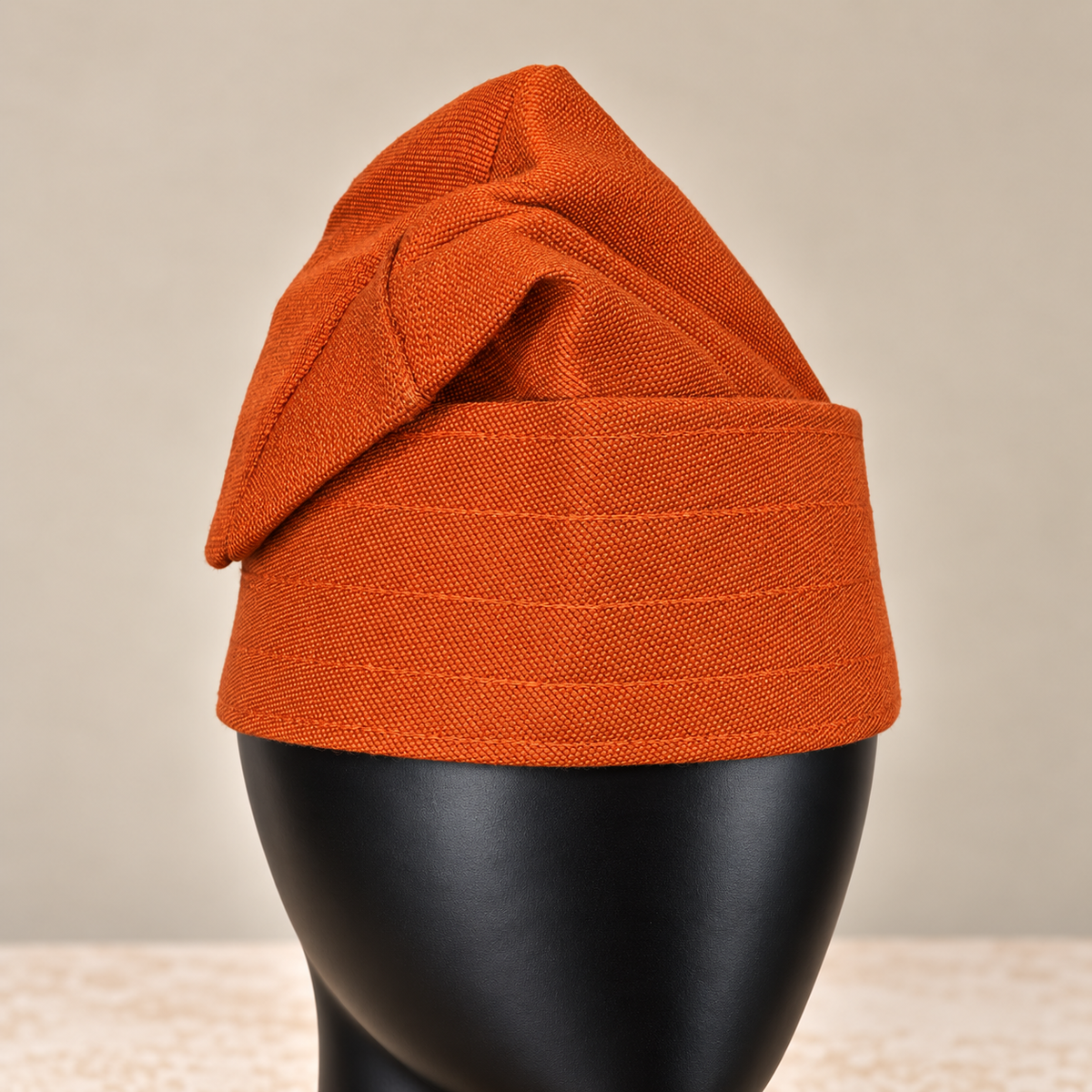 Orange handmade Yoruba Fìlà cap, angled view