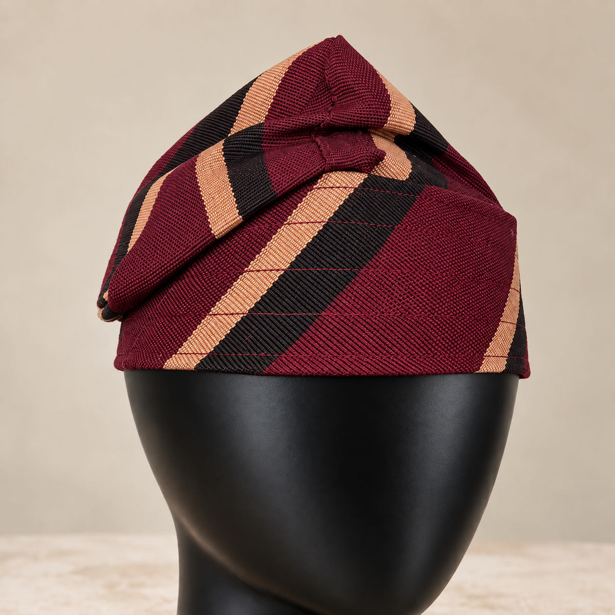 Red handmade Yoruba Fìlà cap, angled view