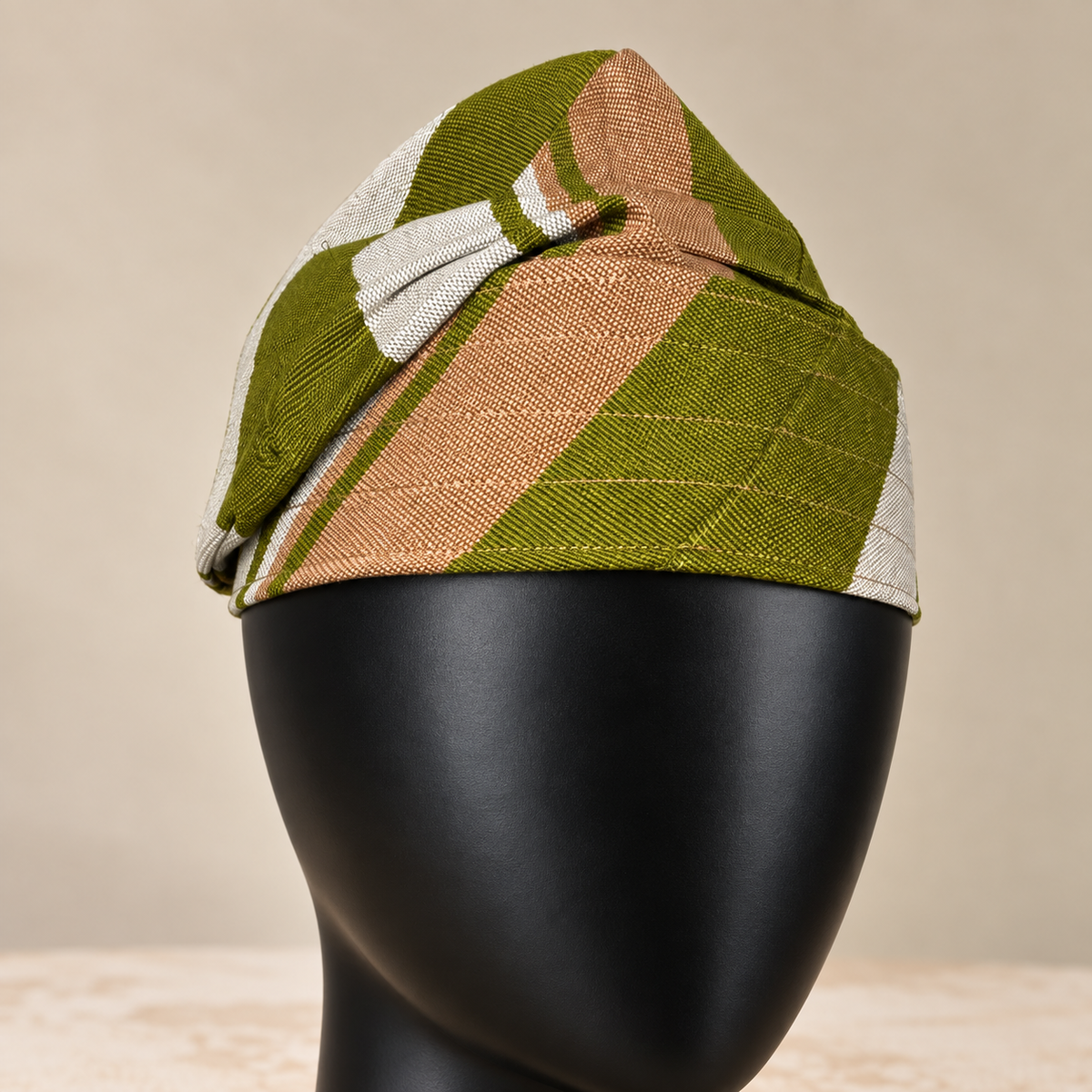 Green handmade Yoruba Fìlà cap, angled view