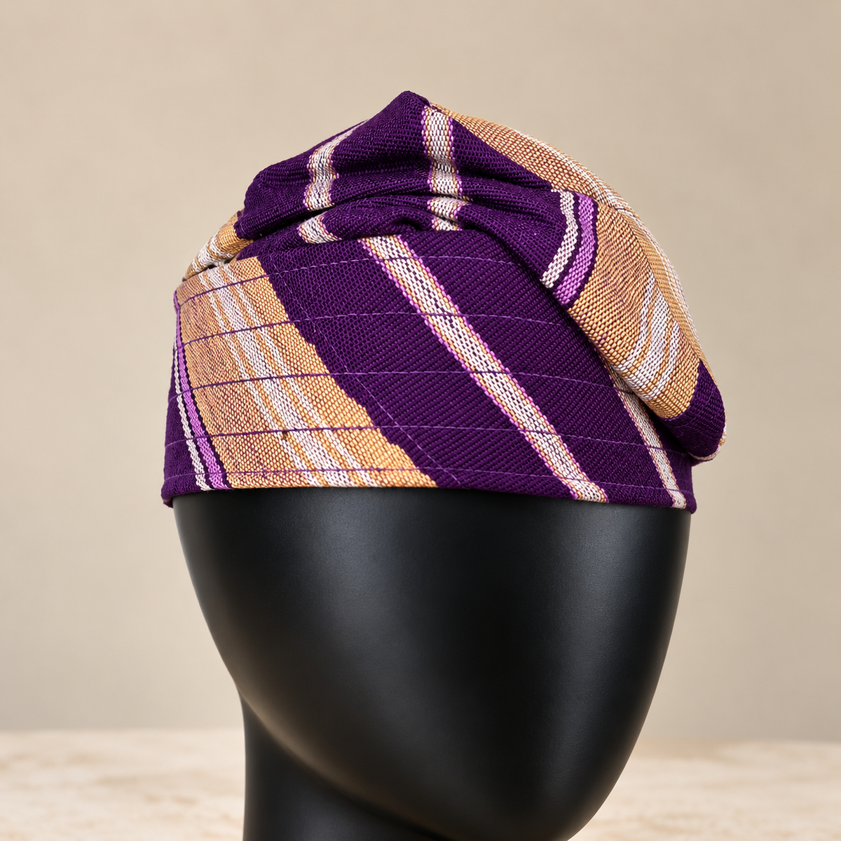 Purple handmade Yoruba Fìlà cap, angled view