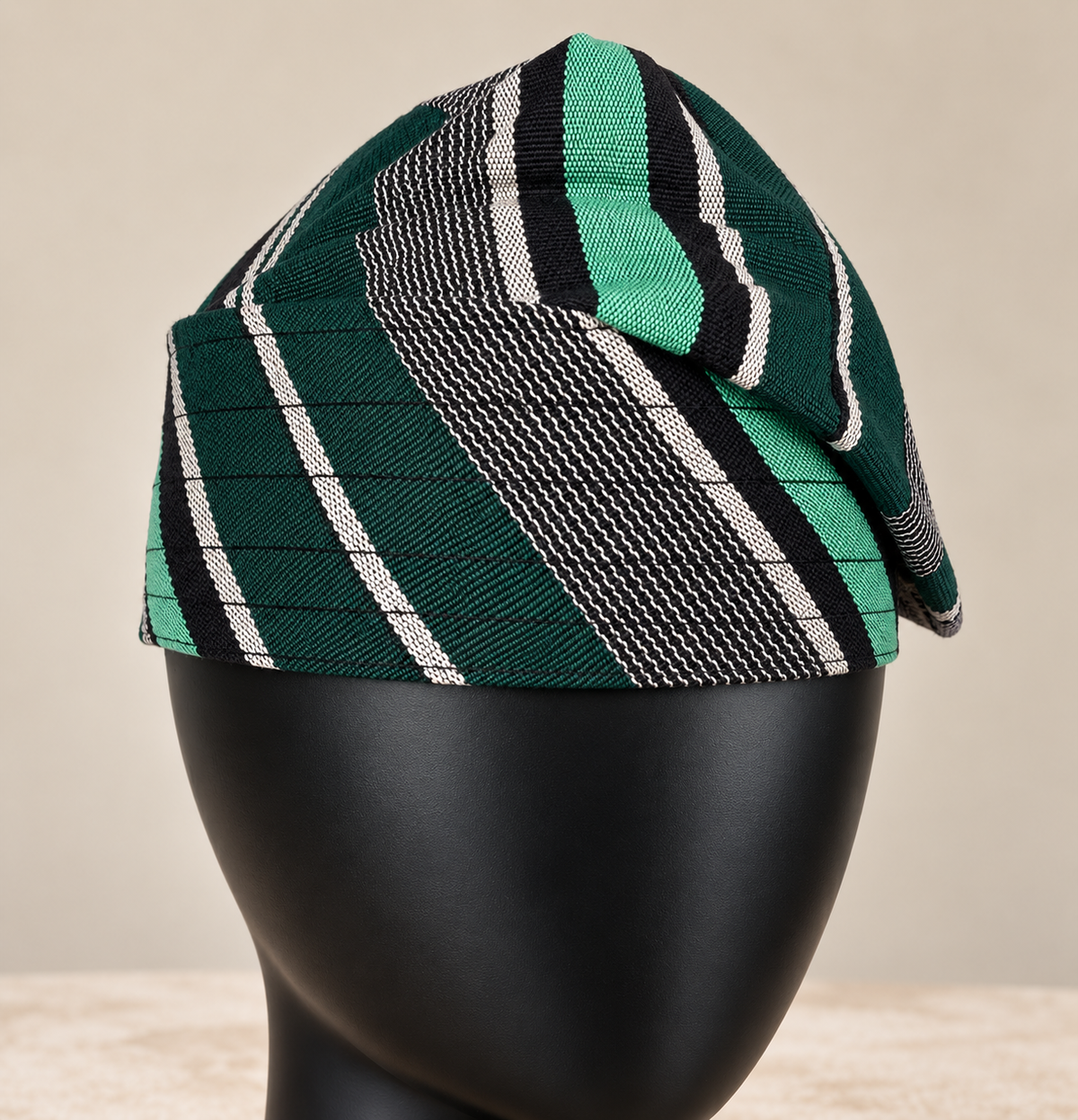 Green handmade Yoruba Fìlà cap, angled view